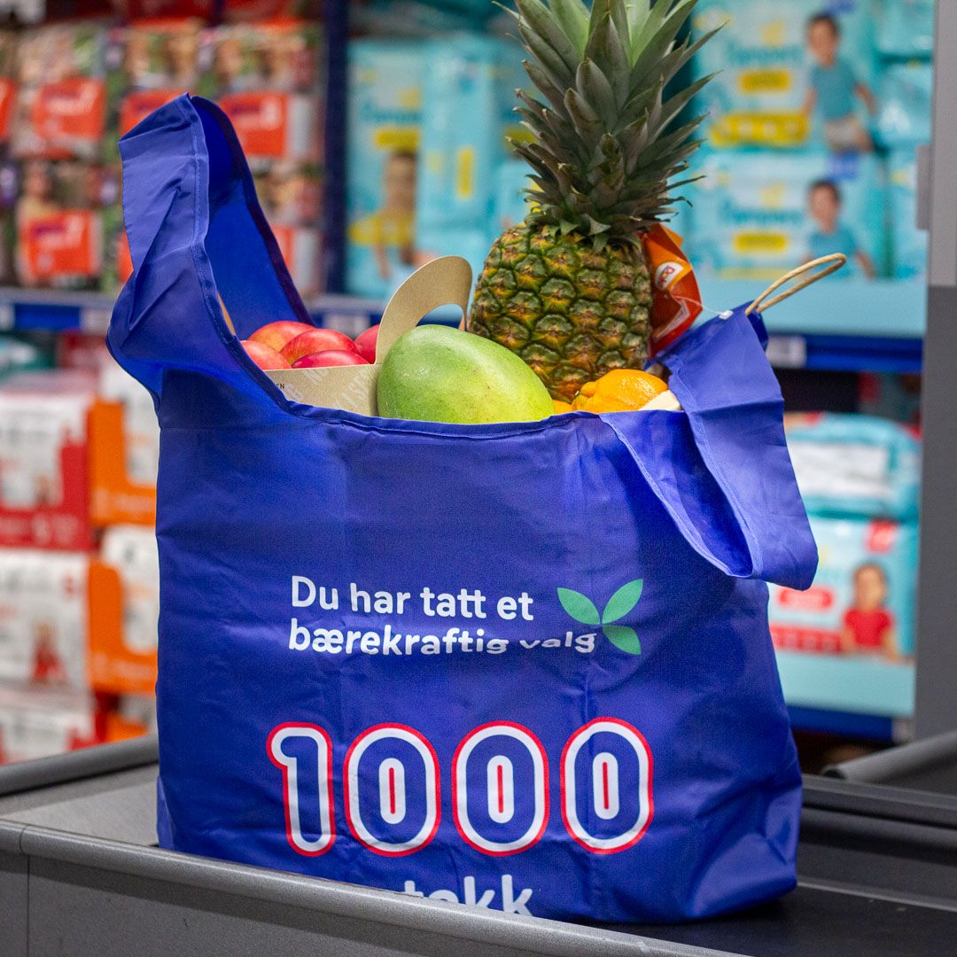 Handlepose fra rema 1000 med frukt og grønt på slutten av kassa