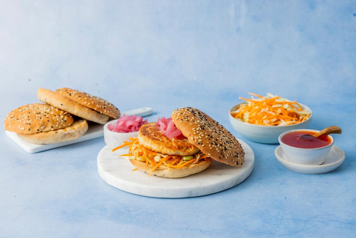 Fiskeburger i hamburgerbrød med råkostsalat og sursøt saus.