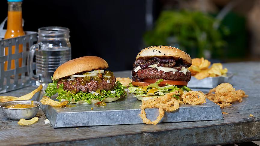 Hamburger med fyll, servert med løkringer. 