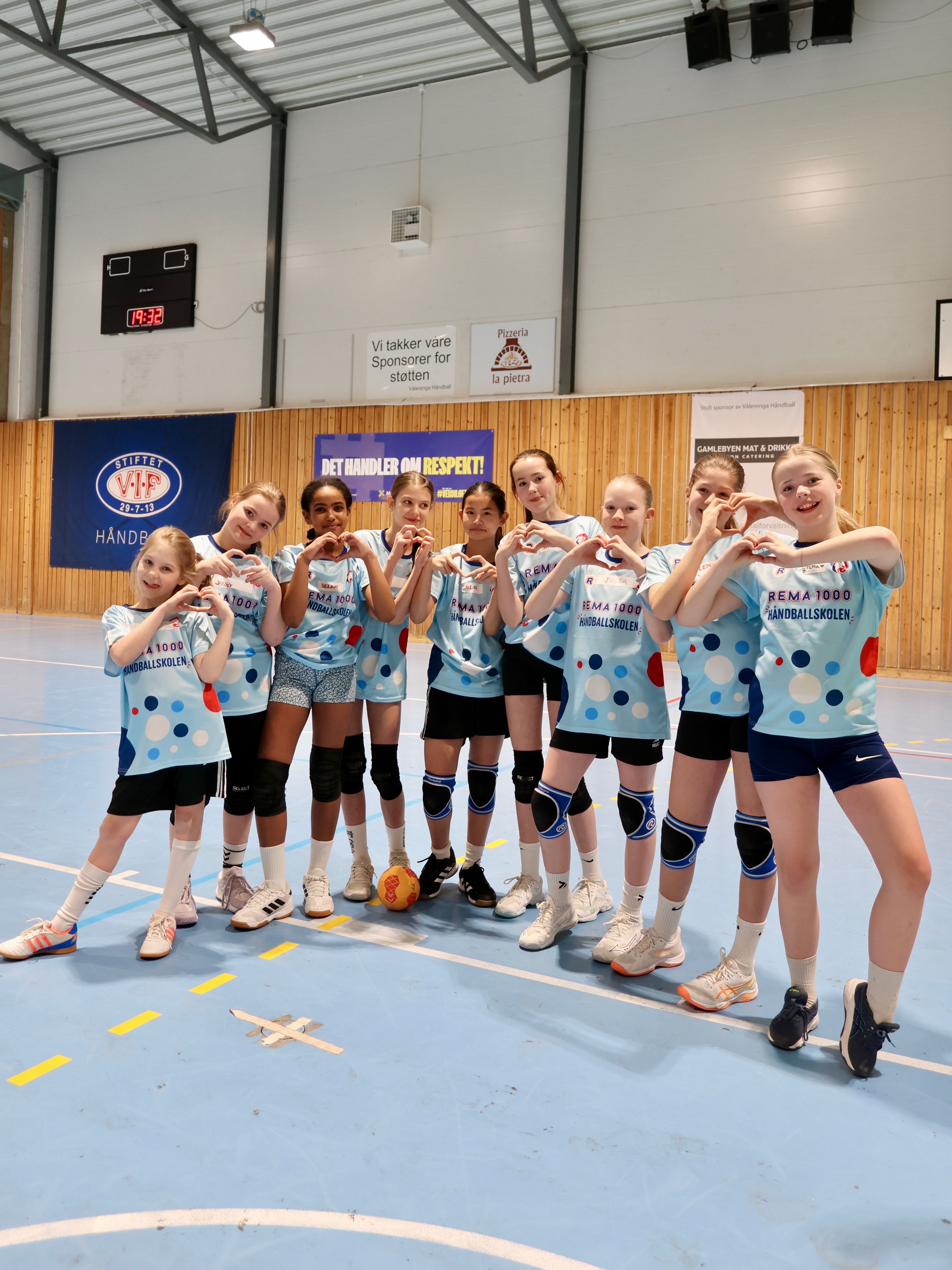 Jentegjeng i håndballdrakt smiler 