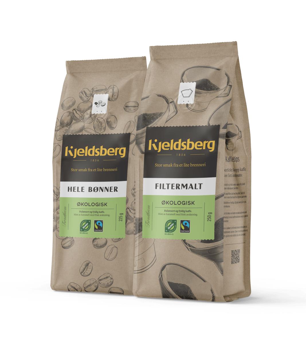 To poser med økologisk kaffe fra Kjeldsberg på svart bakgrunn. Den ene posen inneholder hele bønner, den andre filtermalt kaffe. Begge produktene er Fairtrade-merket og har illustrasjoner av kaffebønner og bryggeutstyr på emballasjen.