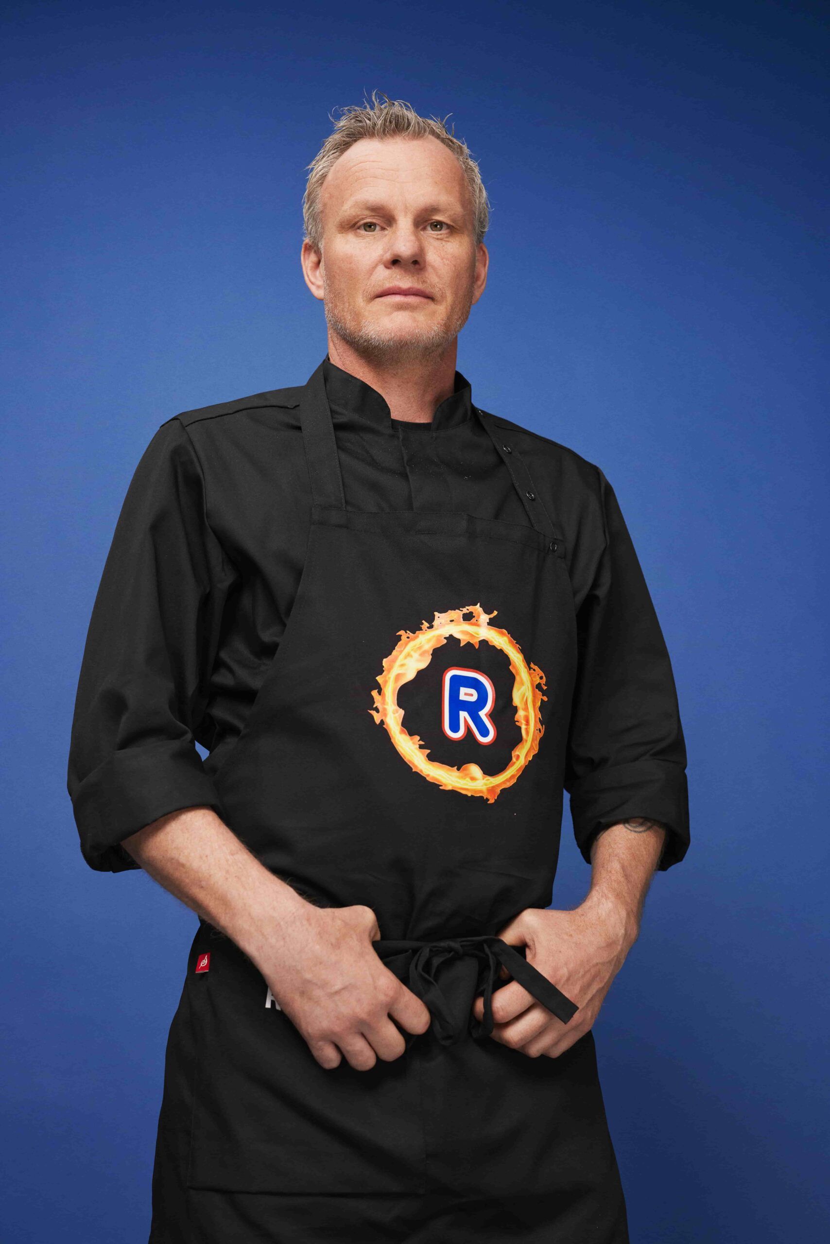 Rune Alexander Nilsen i uniform med Rema R-logo, foran en blå bakgrunn.